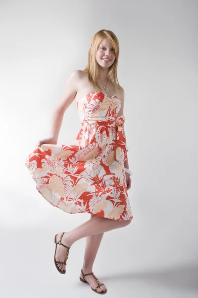 オレンジのドレスでポーズをとるモデルします。 — ストック写真