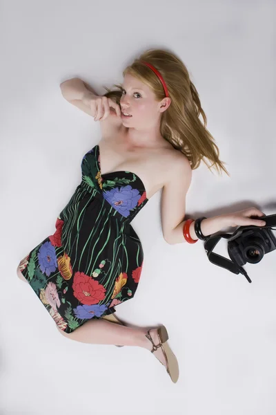 Mujer en vestido sin tirantes con una cámara — Foto de Stock