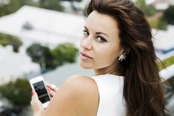 Женщина с натуральным макияжем держит смартфон — стоковое фото