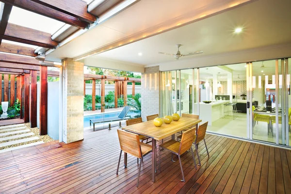 Une vue extérieure de la maison avec table à manger et chambres attenantes — Photo