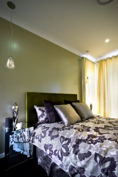 Hermoso dormitorio con cortinas en la pared y cojines — Foto de Stock