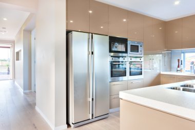 A modern refrigerator in the luxury kitchen with microwave ovens clipart