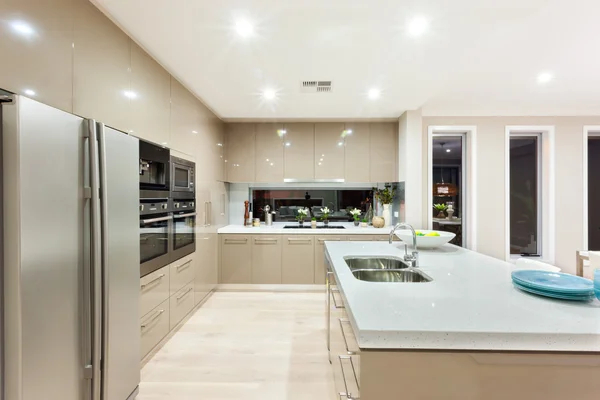 A modern kitchen with refrigerator and fixed to the wall with ca