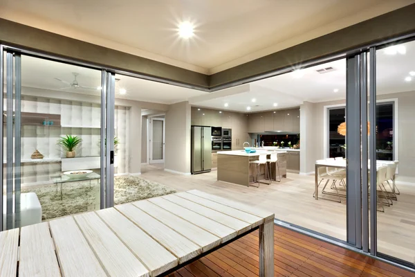 Vista interior de una casa moderna luces encendidas con mesa de madera — Foto de Stock