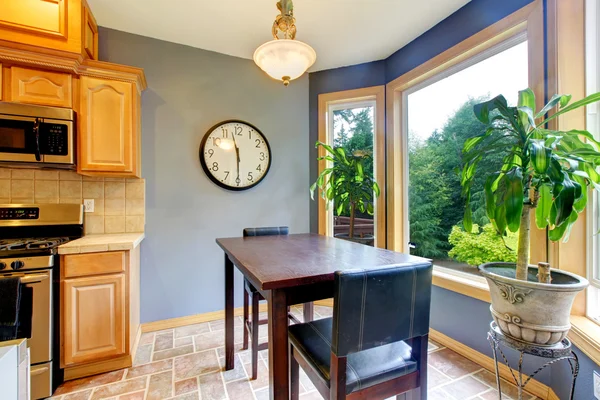 Dining breakfast table near the kitchen with blue walls. — Stock Photo, Image