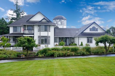 Yeşil bahçe ile büyük beyaz ev.