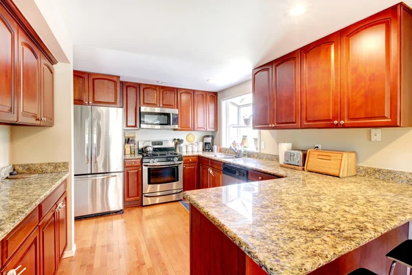 Cocina con piso de madera y gabinetes manchados . — Foto de Stock