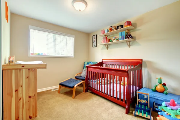 De kamer van de baby met rood gekleurd wieg en lichte interieur. — Stockfoto