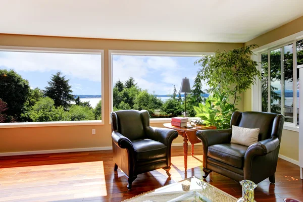 Two leather lounge chairs and large windows in corner of living — Stock Photo, Image