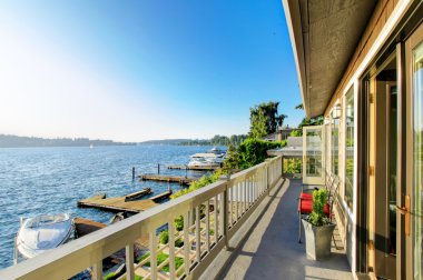 Lüks arka güverte kırmızı sandalye ve su görünümü ile donatılmıştır. Göl