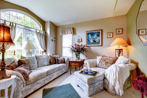 Living room with large rounded window, carpet, and large floral — Stock Photo, Image