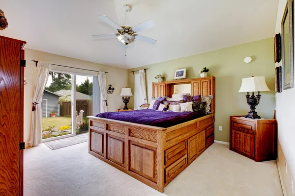 Chambre des maîtres avec tapis gris, ventilateur de plafond et literie violette — Photo