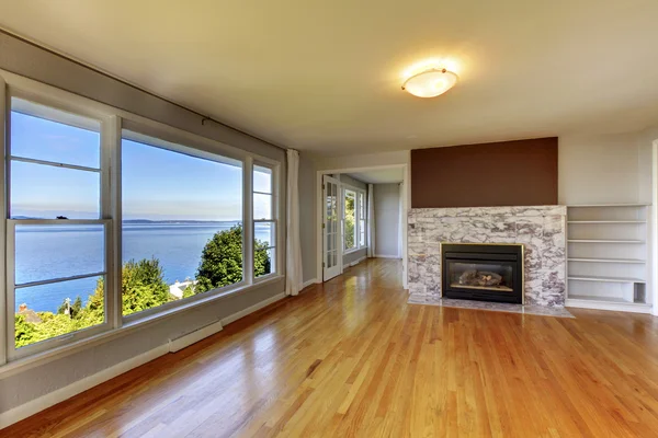 Interiér obývací pokoj s dřevěnou podlahu, krb a vody vi — Stock fotografie