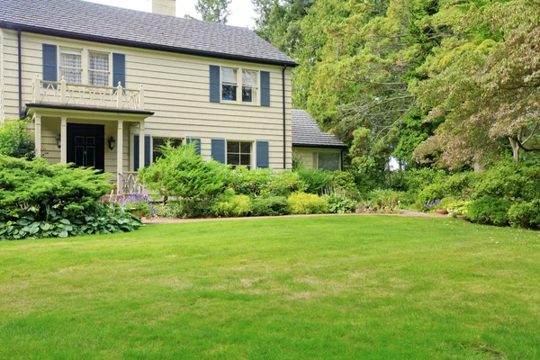 Pequeña casa americana con exterior de luz y un césped lleno de hierba grande — Foto de Stock