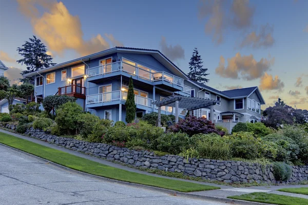 Bonito jardín delantero con casa azul y arbustos . — Foto de Stock