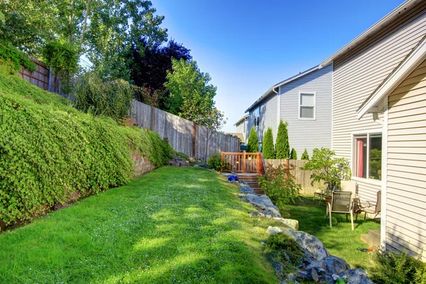 Pequeño patio cercado verde con jardín y cobertizo — Foto de Stock