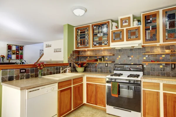 Intérieur de cuisine lumineux avec carrelage brun et armoires colorées — Photo