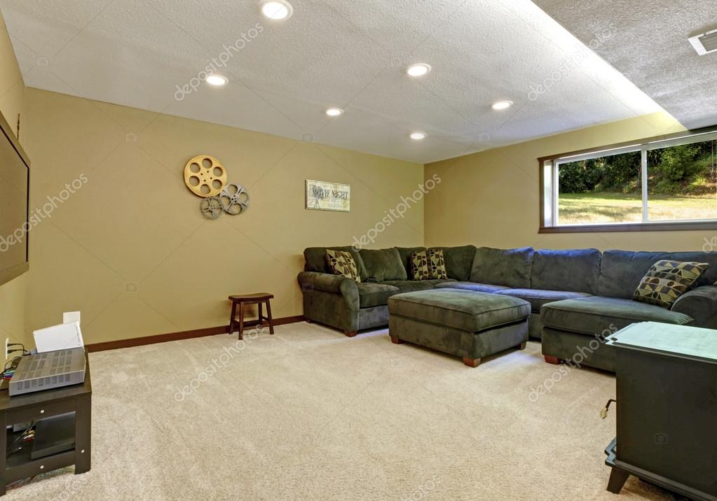 Large Day Light Open Basement With Green Sofa Stove And Tv