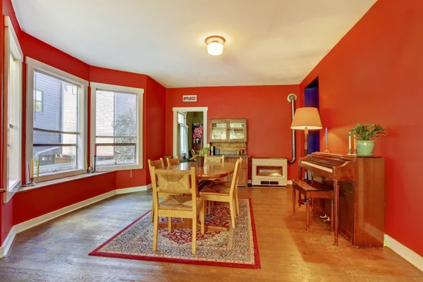 Charm red dining room with vintage wood piano, hardwood floor an — Stock Photo, Image