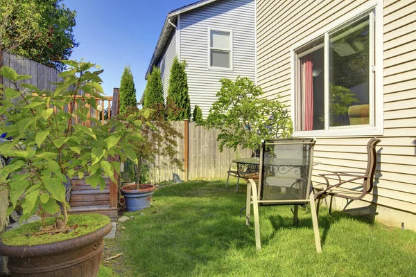 Kleine groene omheinde achtertuin met mooie tuin. — Stockfoto