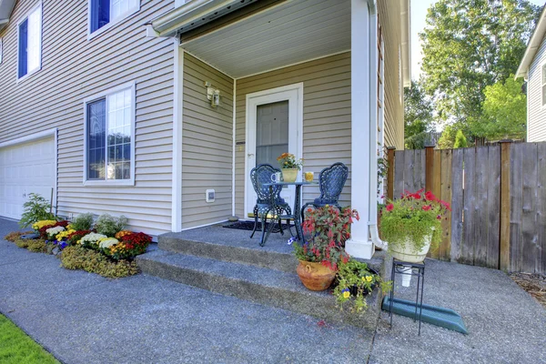 Adorabile casa bianca con bel portico e tavolo in metallo set sedia . — Foto Stock