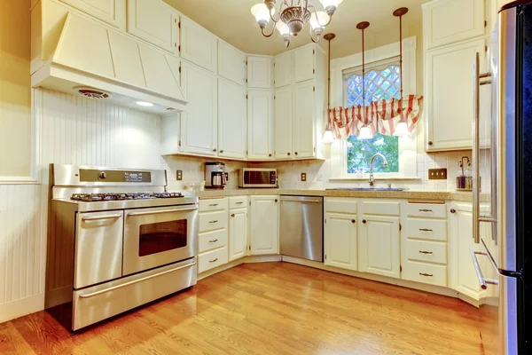 Интерьер с видом на кухню из древесины лиственных пород и белые шкафы — стоковое фото