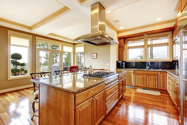 Moderno design della cucina in legno con pavimento in legno, isola, piano di lavoro in granito . — Foto Stock