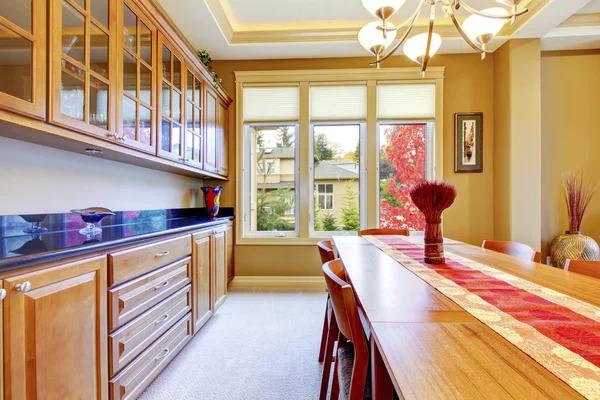 Bel intérieur de salle à manger rouge et marron avec armoires en bois et comptoir en granit bleu . — Photo