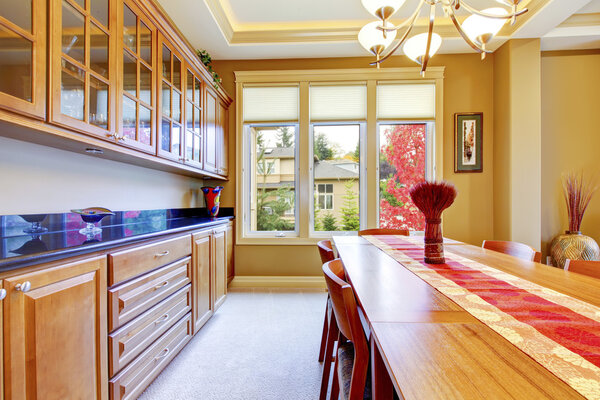 Nice red and brown dining room interior with wooden cabinets and blue granite counter top.