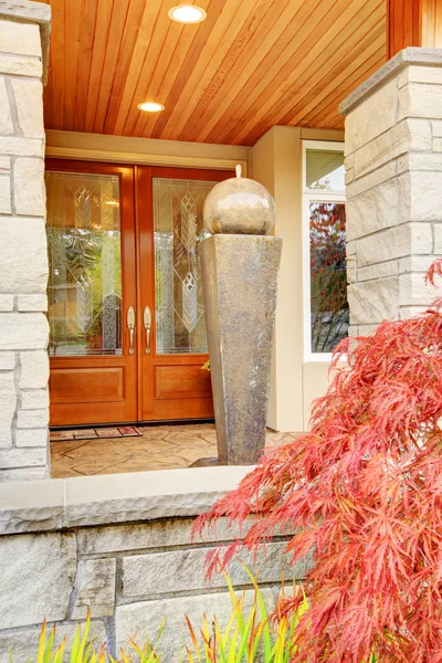 Luxury house entrance porch with stone column trim and wooden door. — Stock Photo, Image