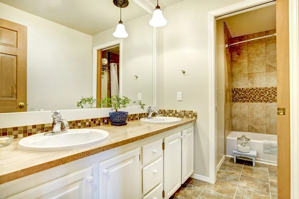 Χρυσό εσωτερικό μπάνιο με ξύλινο λευκό ζωγραφισμένα ντουλάπια. — Φωτογραφία Αρχείου