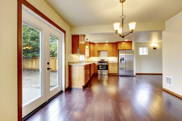 Gran sala de cocina de madera con encimeras de granito, nevera de acero inoxidable . — Foto de Stock