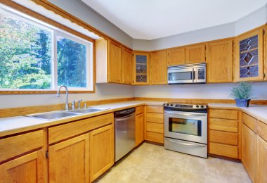 Parlak mutfak oda iç seramik zemin ve hafif kahverengi depolama kabinleri ile.