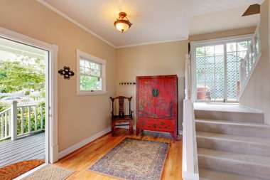 Giriş yolu alanına merdiven, vanity kırmızı dolap ve parke zemin ile yumuşak tonları.