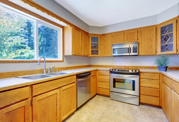 Interior kamar dapur yang terang dengan lantai ubin dan lemari penyimpanan coklat muda . — Stok Foto