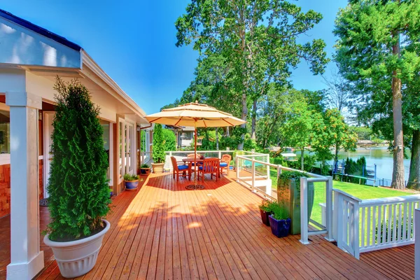 Zitkamer gebied op ruime staking terras met uitzicht op water weergave. — Stockfoto