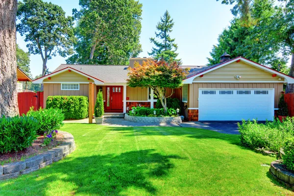 Linda casa pequeña rambler con puerta roja y puerta de garaje blanca . — Foto de Stock