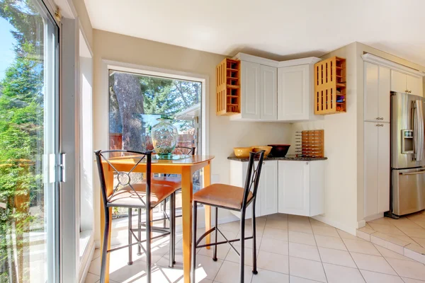 Comedor de tonos claros con mesa marrón y suelo de baldosa . — Foto de Stock