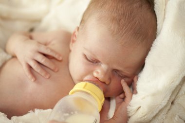 Bebeğin ağzından meme başı ile şişe içme