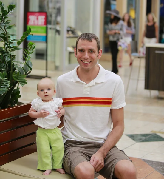 Shopping di famiglia. Giovane padre e sua figlia in panchina . — Foto Stock