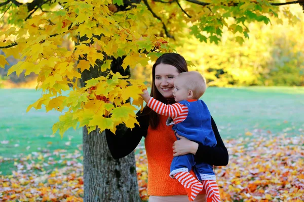 Schöne glückliche Mutter umarmt Baby-Mädchen mit Liebe — Stockfoto