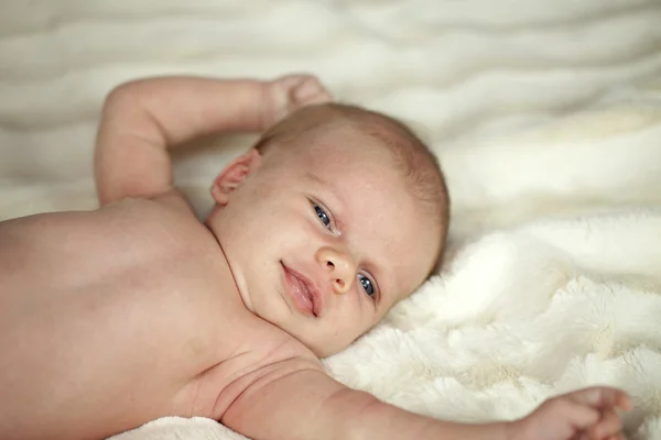 Портрет милого маленького ребенка, лежащего на одеяле — стоковое фото