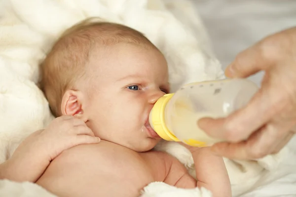 Baby drinking from bottle with nipple in mouth Stock Image