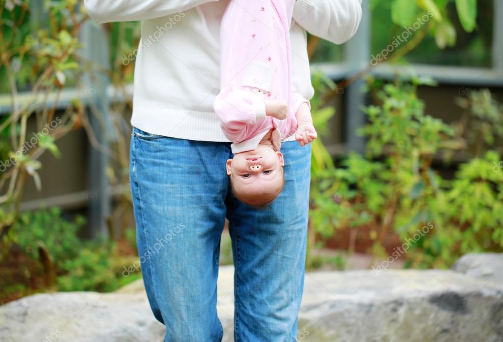 Dad holds the baby upside down outdoor. — Stock Photo © iriana88w
