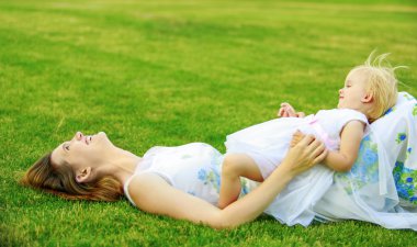 Mutlu anne bebek bir çim üzerinde yalan