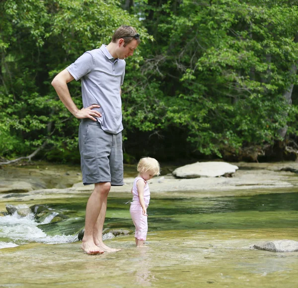 Padre con un bambino cammina nel fiume — Foto Stock