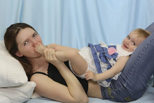 Young Mother kissing baby Feet. Happy childhood — Stock Photo, Image