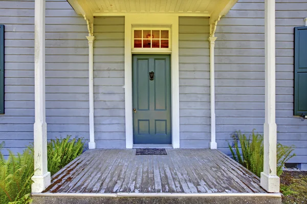 Offene Veranda mit Säulen und blauer Tür eines alten Hauses in Seenholz, wa. USA — Stockfoto