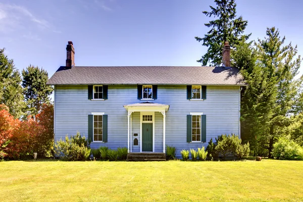 Американский двухэтажный дом с голубой краской и маленькой открытой верандой . — стоковое фото