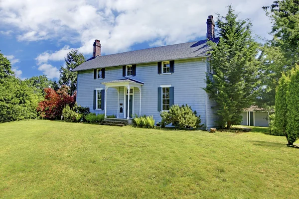 Casa de dos pisos con pintura exterior azul y pequeño porche abierto . — Foto de Stock